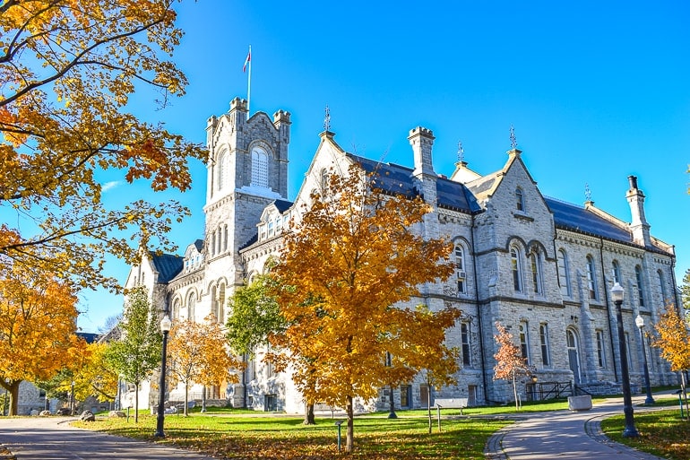 old limestone building with autumn trees at queens university