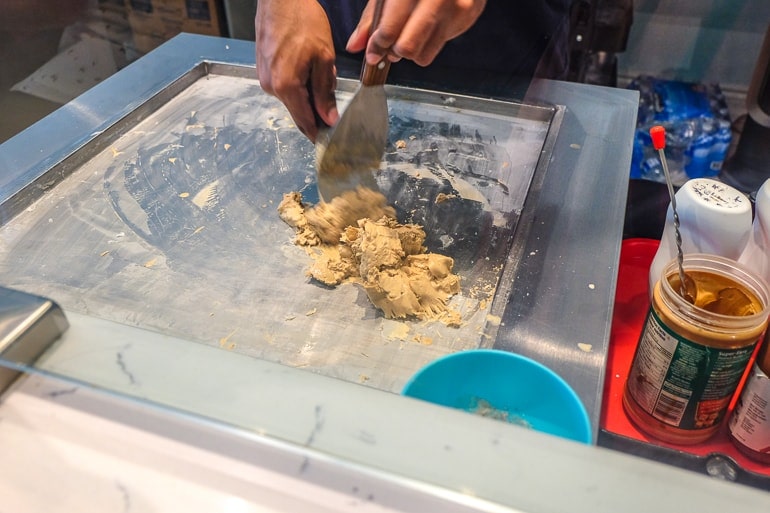 ice cream being prepared on cold metal slab