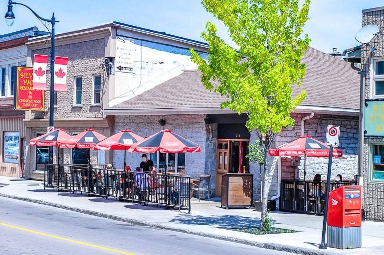 small bar in stone house with sidewalk patio and umbrellas in kingston ontario
