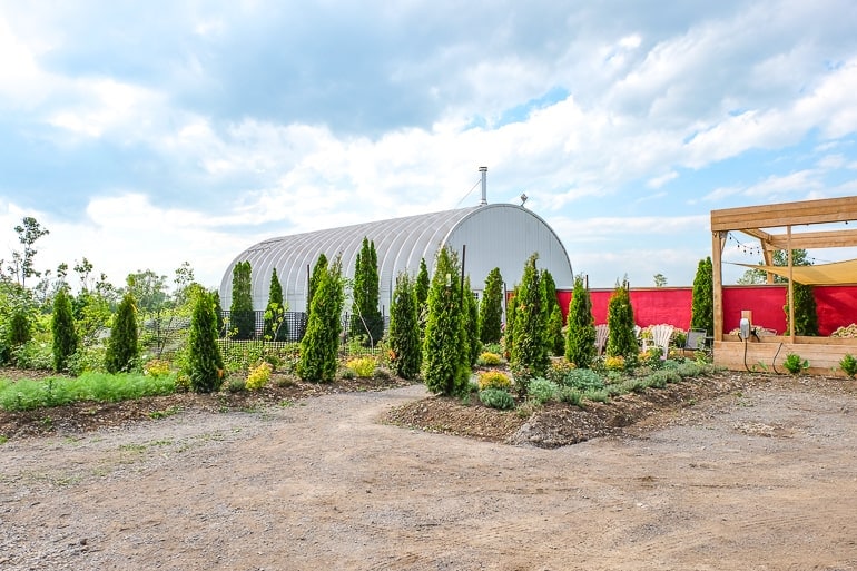 metal barn dome with green trees in front of winery