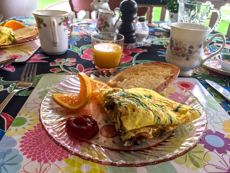omelette on plate with fruit and coffee on table at bed and breakfast