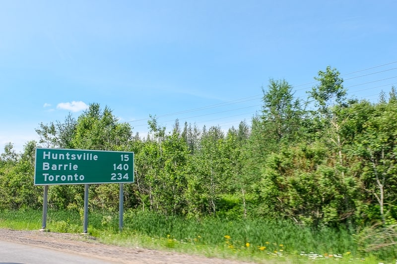 green highway distance sign on side of road in ontario