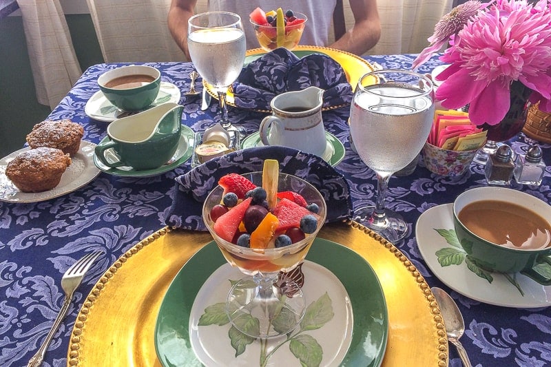 breakfast fruit salad on table with blue cloth and plates