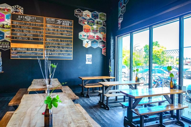 wooden benches and beer on menu on wall inside brewery in guelph