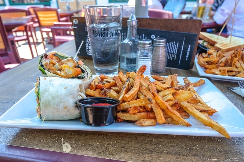 plate on table with fries and a wrap at pub