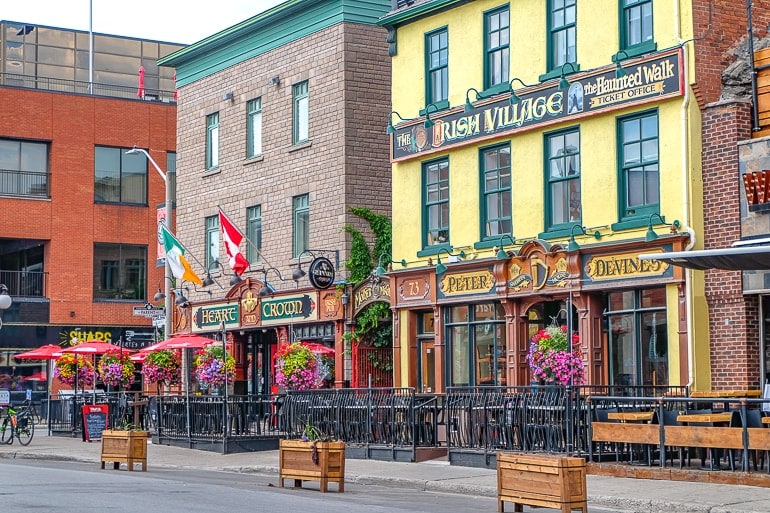 two traditional irish pub shop fronts with sidewalk in front