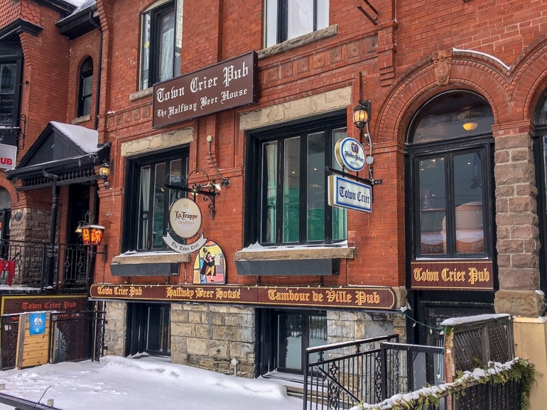 old pub in red brick with small snowy patio in front