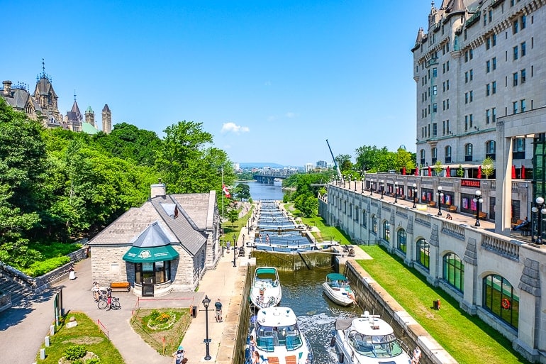 boats in locks with trees and hotel beside in ottawa rideau canal.