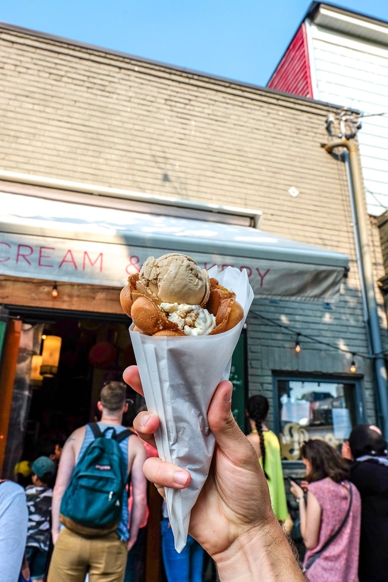 ice cream cone on paper wrapper in front of storefront in toronto