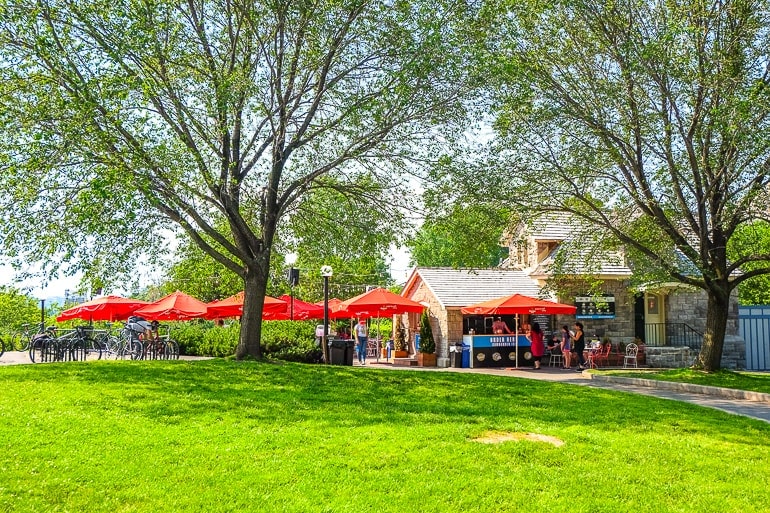 red umbrellas over patio area with green grass in front