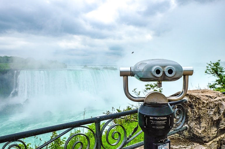 viewfinder on metal pole in sidewalk viewing large waterfalls.