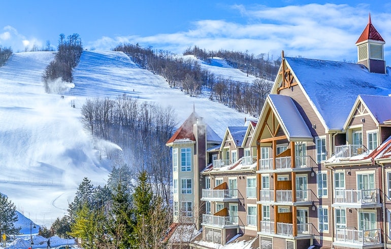 chalet buildings with snowy sky resort hill behind