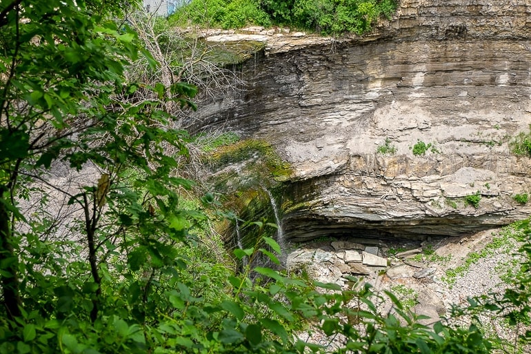 small waterfall with rocky cliff behind in hamilton ontario