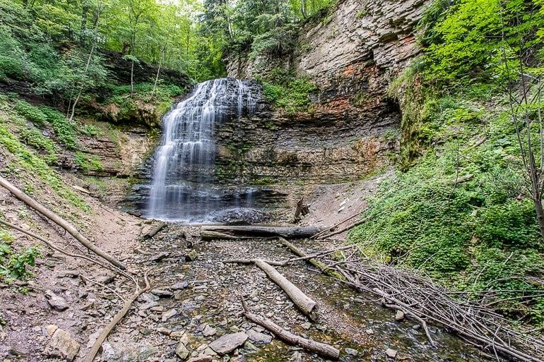 waterfall falling into large rocky opening with forest surrounding in hamilton ontario.