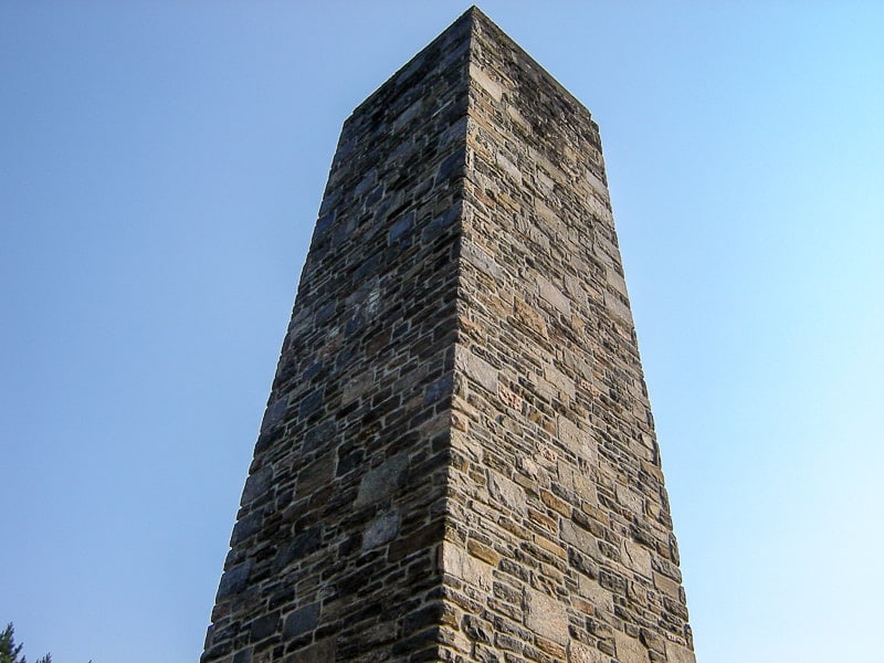large stone obelisk with blue sky behind
