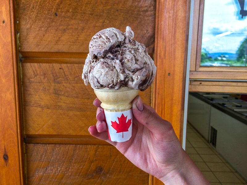 hand holding ice cream cone with canadian maple leaf on handle