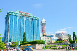 blue glass hotel with casino beside and blue sky above