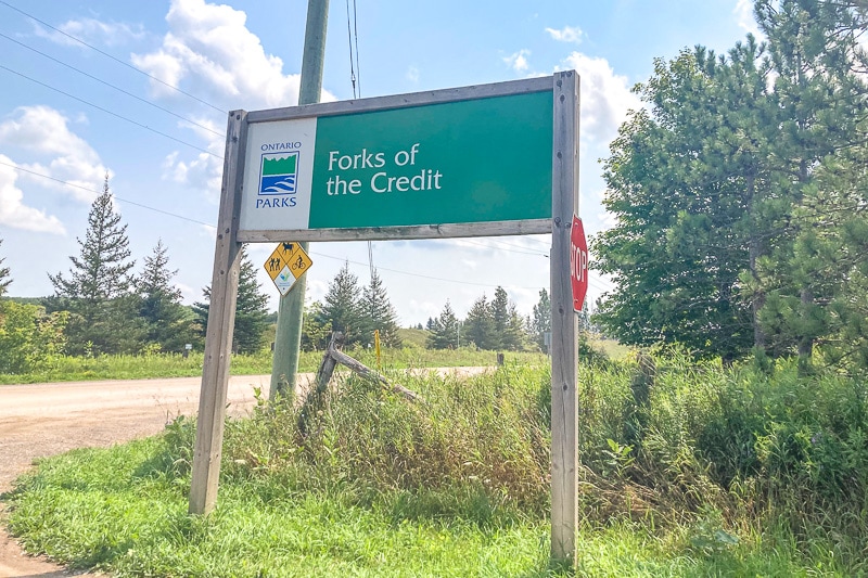 green entrance sign beside road for forks of the credit park.