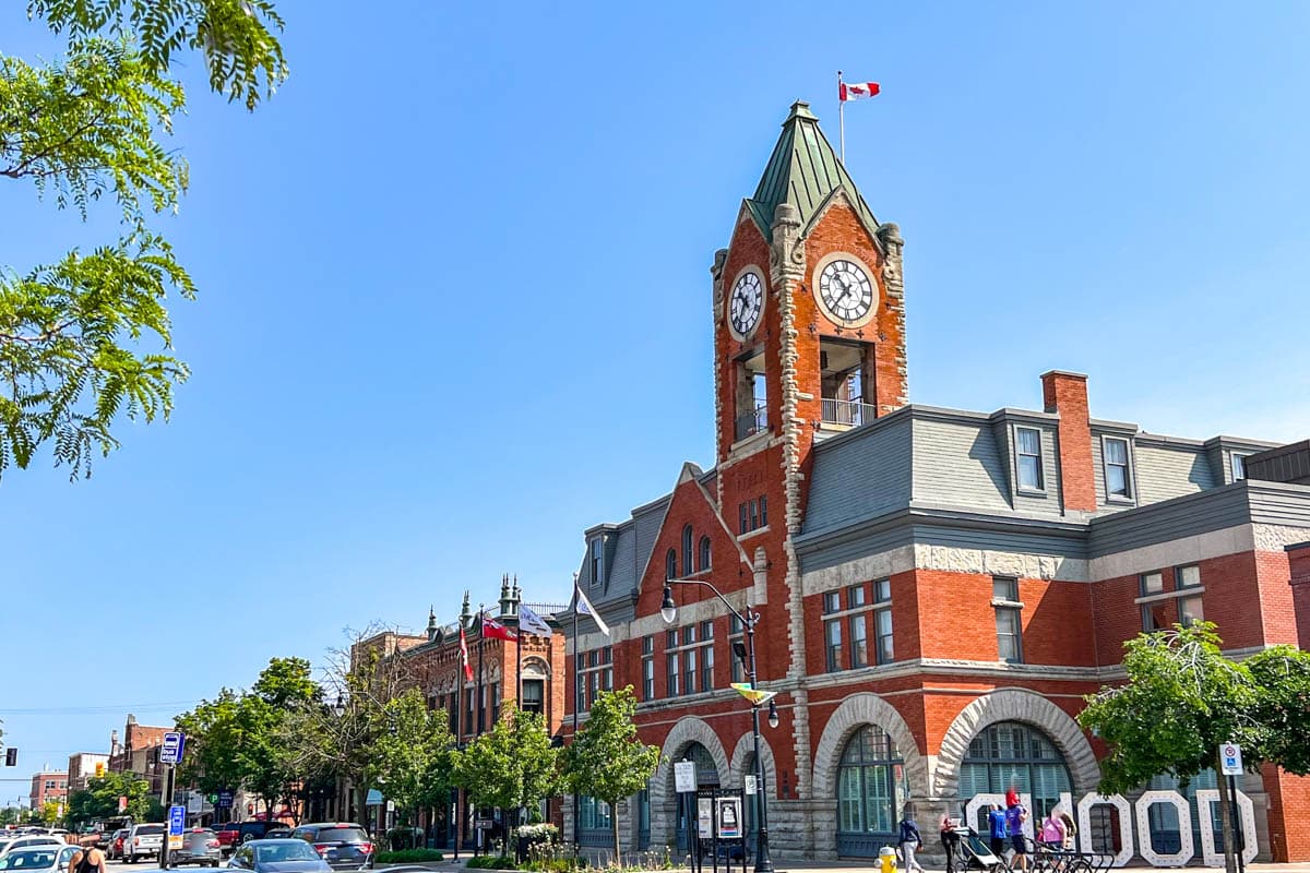 large old red brick town hall building with clock and flag on top in downtown collingwood ontario.