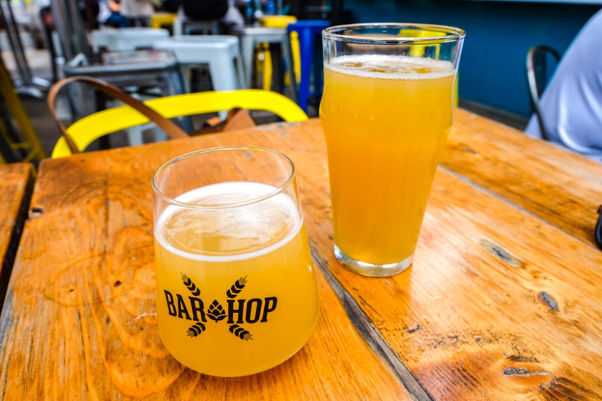 two glasses of orange beer on wooden table.