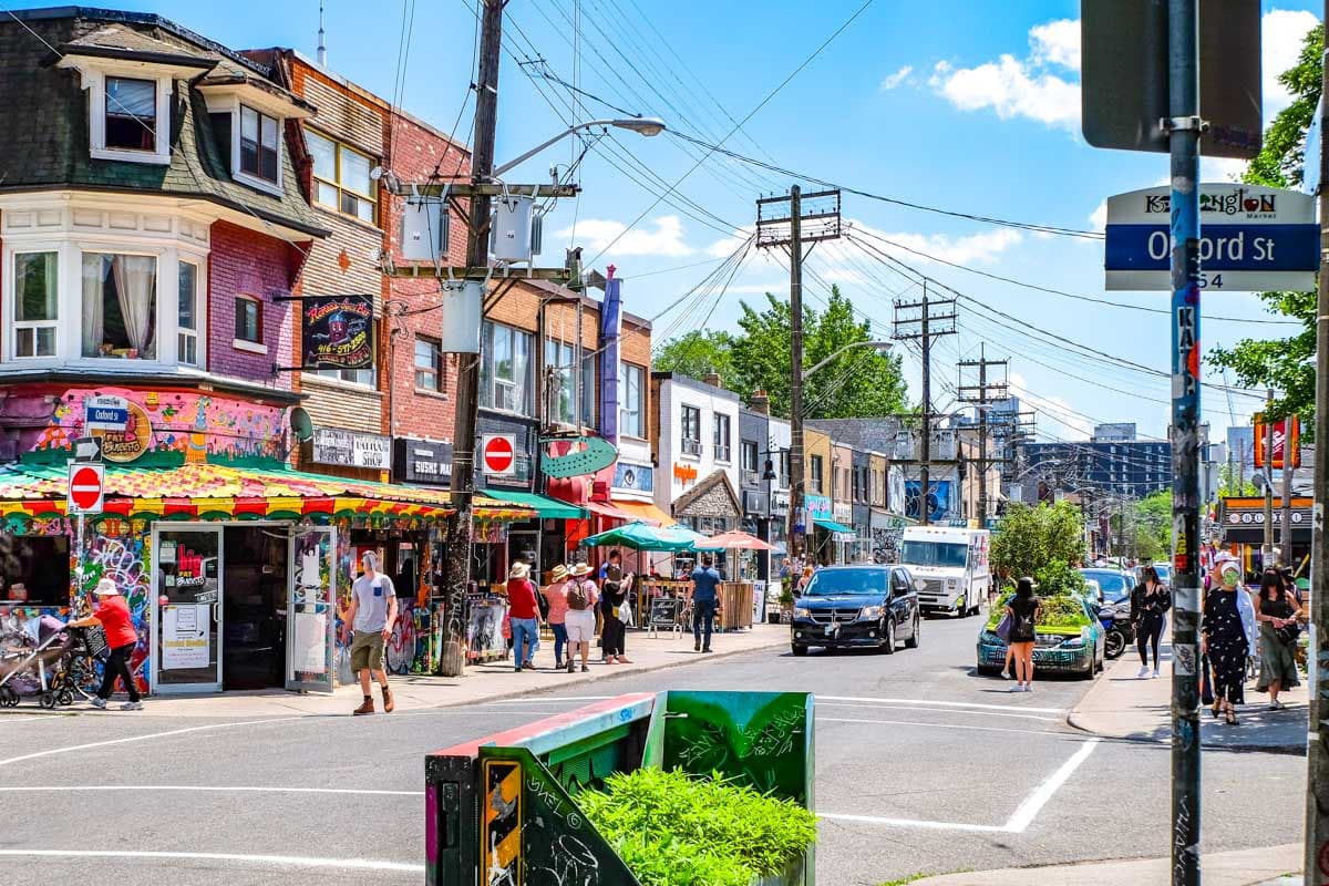 colourful shopfronts with intersection in foreground in kensington market in toronto.